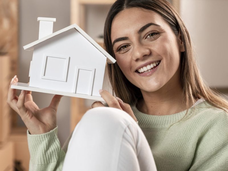 medium-shot-woman-holding-small-house